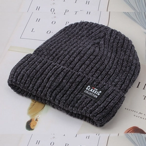 Detail of dark grey ribbed knit beanie with Classic Collection patch on a magazine background