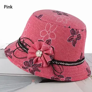 Détail du chapeau bob rose à motif floral avec fleur en tissu et perle sur textile