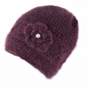Detail of purple knitted wool hat with crochet flower and faux pearl accent