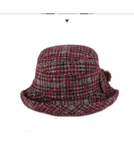 Vue de face d'un chapeau cloche d'hiver à carreaux avec pompon en peluche décoratif