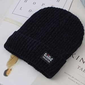 Detail of dark blue knit beanie featuring a classic collection woven patch and ribbed texture