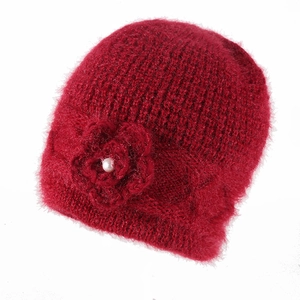 Detailed texture of fuzzy dark red knit hat with handcrafted flower and pearl accent