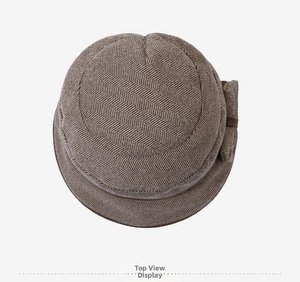 Top view of dark brown wool cloche hat showing herringbone texture and bow detail