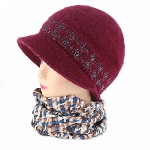 Detailed close-up of winter burgundy knit visor hat and plaid scarf set on model