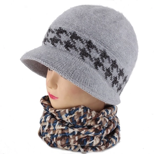 Close-up of grey houndstooth knit visor hat and plaid neck gaiter on a model head