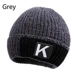 Detail of grey winter knit beanie with thick fleece lining and black 'K' logo patch