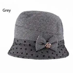 Close-up of grey cloche hat with houndstooth pattern and metallic rose gold flower