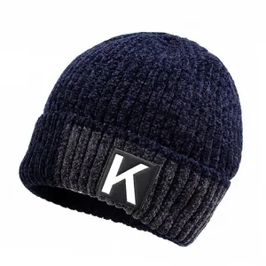 Close-up of a blue winter beanie with gray stripes and a square leather letter K patch