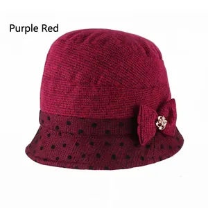 Detail of burgundy knitted hat featuring a polka dot brim and decorative bow with rhinestones