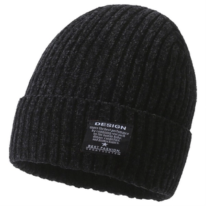 Close-up of black knit beanie featuring vertical ribbed texture and a design label