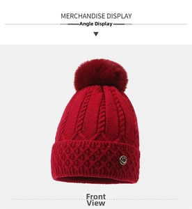 Rote Strickmütze mit Zopfmuster, flauschigem Bommel und goldenem Smiley-Metall-Emblem