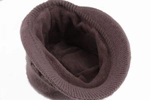 Detail view showing the thick faux fur lining and ribbed knit texture of a brown winter hat