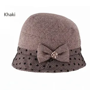 Detail of khaki cloche hat with polka dot brim and rhinestone bow ornament