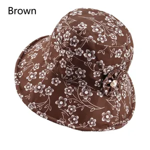 Detail of a brown floral bucket hat with decorative fabric flower and pearl accent