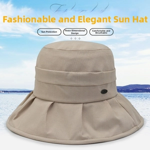 Detail of beige sun hat with wide pleated brim and metallic buckle decoration