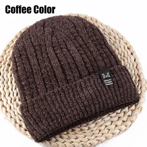 Detail of coffee brown cable knit beanie with embroidered M logo on textured background