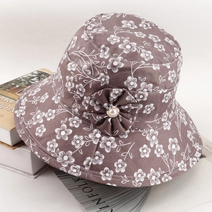 Detail view of brown sun hat with white floral print and pearl flower decoration