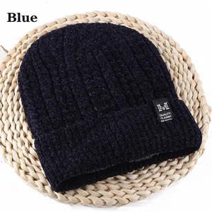 Detail of navy blue winter beanie with vertical knit texture and square M logo patch