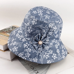 Close-up of floral pattern bucket hat with fabric flower and pearl button detail