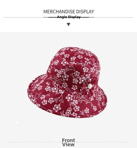 Detail view of dark red cotton sun hat with white floral print and pearl flower button