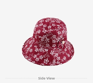 Detailed close-up of burgundy floral sun hat featuring white flower patterns and pearl accents