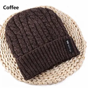 Close-up of coffee brown knit beanie with cable stitch pattern and brand label detail