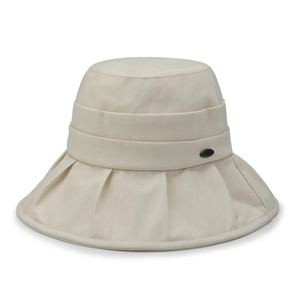 Women's foldable beige bucket hat with wide brim for sun protection and breathable cotton fabric