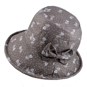 Detail of grey sun hat with white leaf print and a decorative side bow accessory