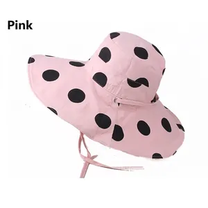 Pink wide brim sun hat with black polka dots and adjustable chin strap for women