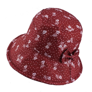 Close-up of dark red floral bucket hat with white leaf patterns and side bow detail