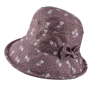 Detail of dark brown bucket hat featuring white leaf print and a side bow decoration