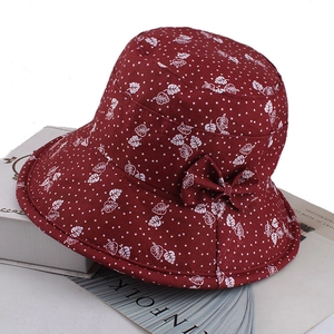 Close-up of a burgundy floral bucket hat with white dots and bow on Kinfolk magazine