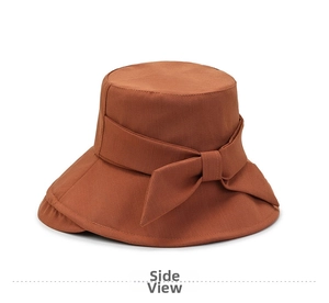 Detailed side view of dark orange bucket hat with an elegant fabric bow decoration