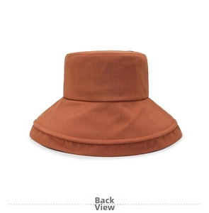 Detail view showing rust red cotton bucket hat with unique layered back brim design