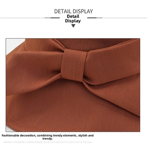 Close-up of caramel bucket hat showing fabric texture and bow tie detail