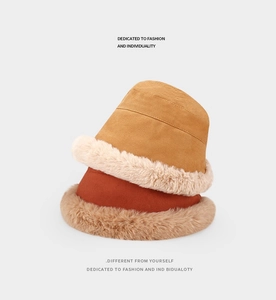 Detail of warm reversible bucket hats in yellow and rust red with soft faux fur lining