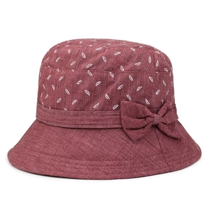 Détail du chapeau de soleil bordeaux avec motif de feuilles et nœud en tissu