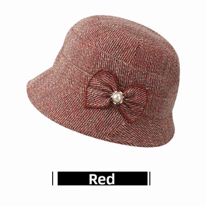 Close-up of red tweed bucket hat with decorative bow and central faux pearl detail