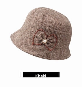 Detail view of khaki textured bucket hat featuring side bow and faux pearl embellishment