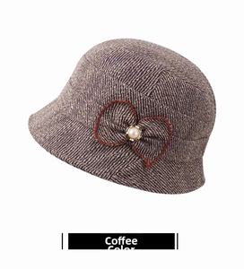 Detailed close-up of brown cloche hat with textured tweed, bow, and pearl accent