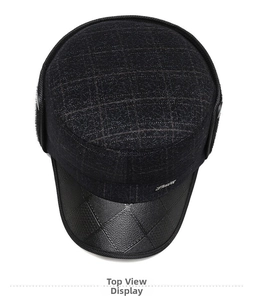 Vue de dessus d'une casquette d'hiver en tissu à carreaux gris avec visière en cuir