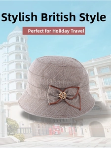 Close-up of tan twill cloche hat featuring a delicate bow and golden floral buckle