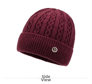 Detail view of burgundy knitted beanie showing thick cable pattern and silver metal logo