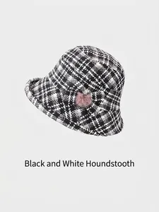 Women's black and white houndstooth wool bucket hat with bow and pink pompom detail