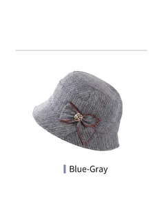 Detailed blue grey knitted bucket hat featuring a decorative bow and golden metal flower buckle