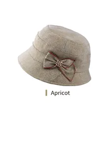 Detail of apricot cloche hat with herringbone texture and elegant bow accent