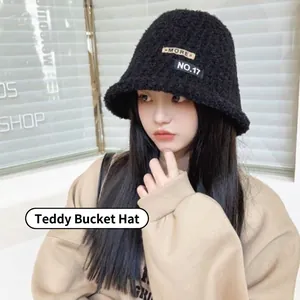 Women's black teddy fleece bucket hat with patch embroidery shown on model