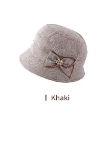 Detail of khaki twill bucket hat featuring a side bow and golden floral metal buckle