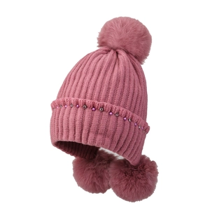 Detail of pink knitted earflap hat with decorative beads, rhinestones and faux fur pom poms