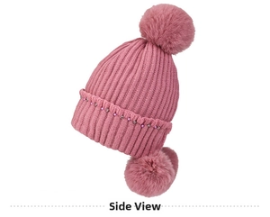 Close-up of pink knit hat featuring faux fur pom-poms and delicate beaded rhinestone accents